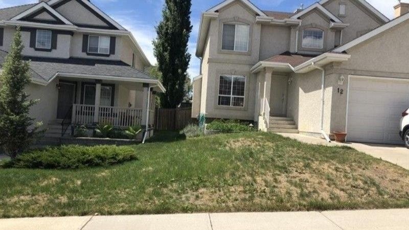 Front lawn with dry brown patches showing possible chinch bug damage during hot summer weather
