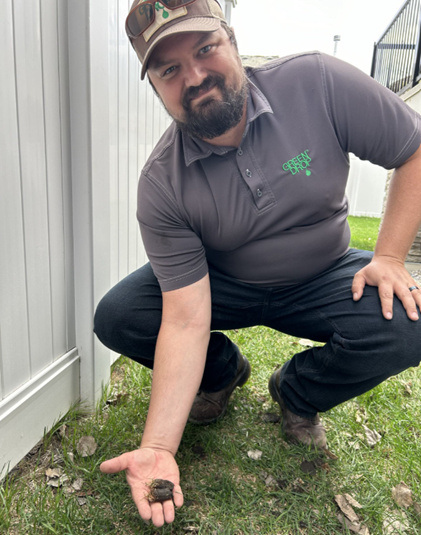 Green Drop technician holding a compacted soil plug over grass