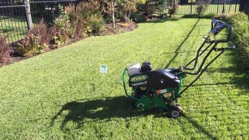 Core aeration machine on a green residential lawn