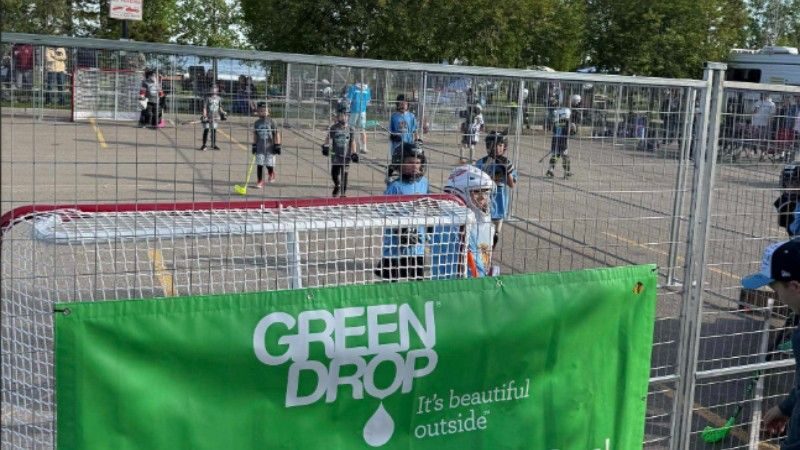 Green Drop banner displayed beside the rink as young players compete in the Battle at the Beach ball hockey tournament.