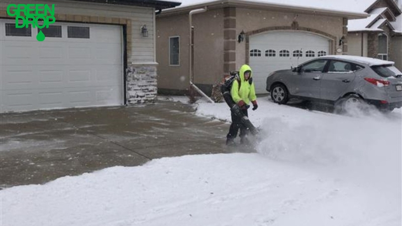 Green Drop worker removing snow from a parking spot
