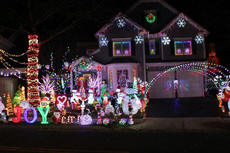 House and front yard decorated with multicoloured Christmas lights and illuminated figures