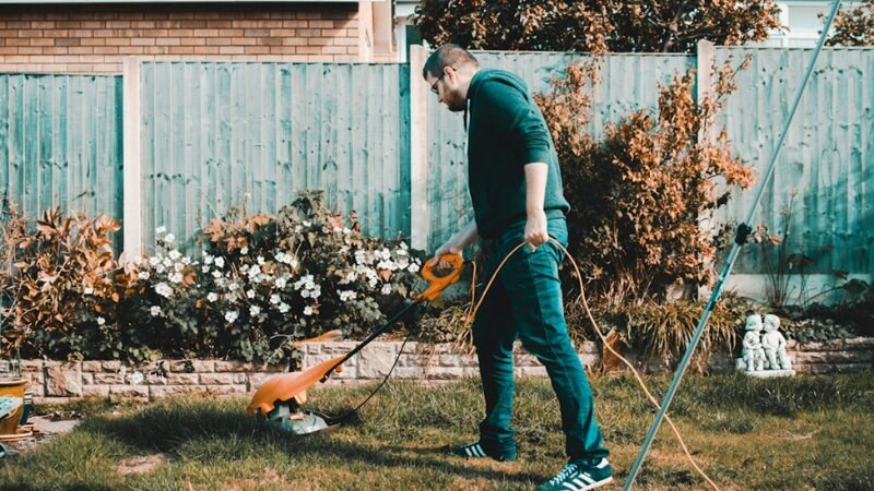 person mowing a lawn with an electric mower