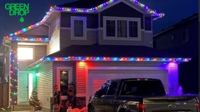 A two-story house decorated with multicolour holiday lights installed by professionals, creating a bright and festive exterior.