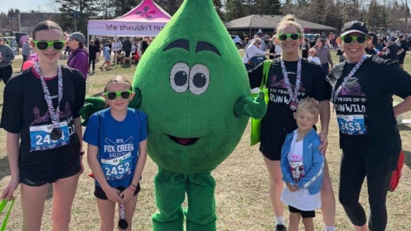 Mr. Green Drop posing with runners and families at the RunWild event in St. Albert